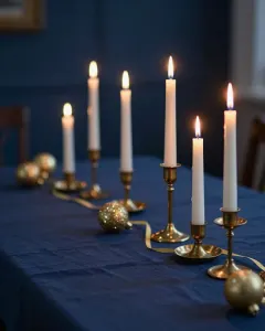 Festlich gedeckter Tisch mit Kerzen und goldenen Bändern vor dunkelblauem Hintergrund