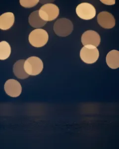 Warme goldene Lichtpunkte vor nachtblauem Hintergrund