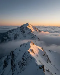 Sonnenaufgang über einem verschneiten Berggipfel