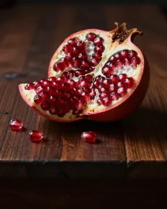 Aufgebrochener Granatapfel auf einem dunklen Holztisch