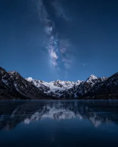 Zugefrorener Bergsee unter einem klaren Sternenhimmel